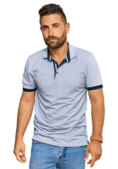 Fototapeta premium Handsome man with beard wearing casual clothes relaxed with serious expression on face. simple and natural looking at the camera.