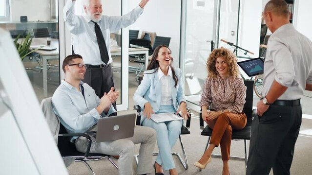 Successful business elderly man finishing a presentation and colleagues applauding 