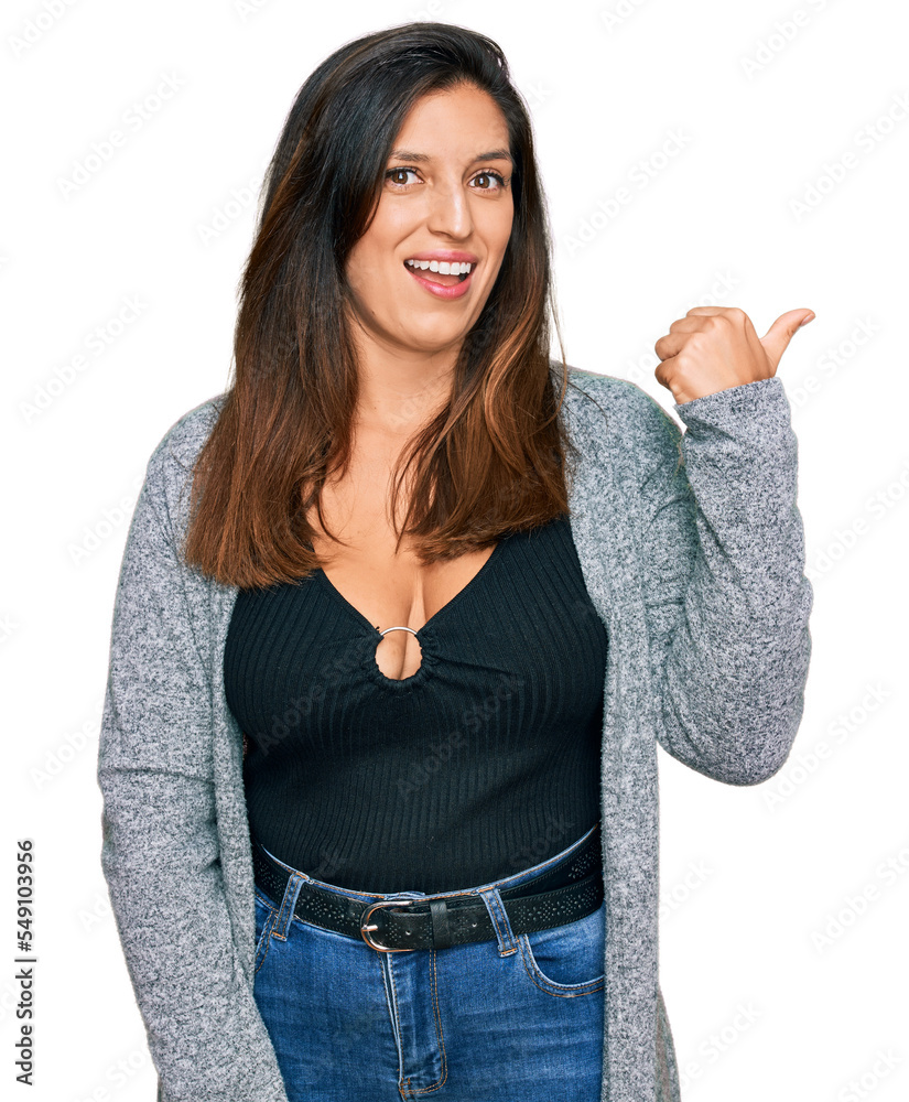 Canvas Prints Beautiful hispanic woman wearing casual clothes smiling with happy face looking and pointing to the side with thumb up.