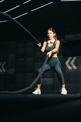 athletic asian woman slim body training and exercising with battle rope in gym bodybuilder, fitness, workout, sport concept.