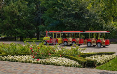Trackless train, children's steam locomotive with wagons - a modern attraction in the city park Kremenchuk city, Ukraine
