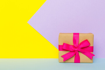 holiday paper present tied pink ribbon bow top view with copy space. Flat lay holiday background. Birthday or christmas present. Christmas gift box concept with copy space