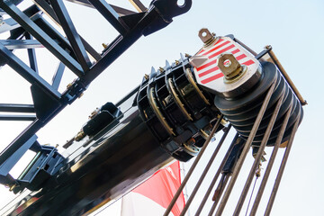 The boom of a wheeled crane and a rope for lifting loads in close-up. Heavy industrial mobile crane. View of a mobile crane on a construction site with cable control and a telescopic boom © Pokoman