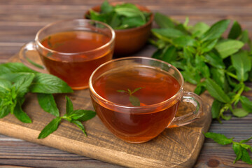 Cup of mint tea on table background. Green tea with fresh mint top view with copy space