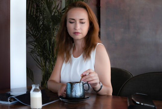 Close Up Of Young Woman Stirring Coffee