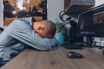 Side view of tired male freelancer sleeping at table while feeling exhausted after work from home 