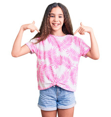 Fototapeta na wymiar Cute hispanic child girl wearing casual clothes looking confident with smile on face, pointing oneself with fingers proud and happy.