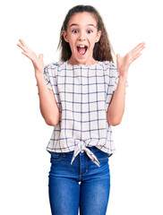 Cute hispanic child girl wearing casual clothes celebrating crazy and amazed for success with arms...