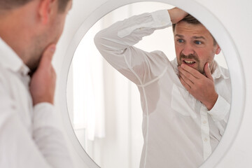 Man with hyperhidrosis sweating very badly under armpit