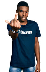 Young african american man wearing volunteer t shirt showing middle finger, impolite and rude fuck off expression