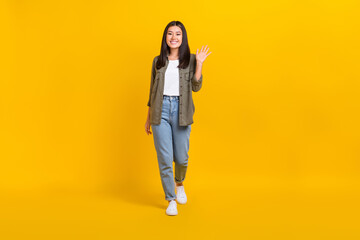 Fototapeta na wymiar Full body size photo of young cute smiling model japanese girl wear casual outfit palm shaking hello isolated on bright yellow color background