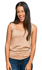 Obraz premium Beautiful hispanic woman wearing casual clothes winking looking at the camera with sexy expression, cheerful and happy face.