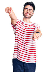 Naklejka premium Young hispanic man wearing casual clothes pointing to you and the camera with fingers, smiling positive and cheerful