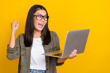 Photo of impressed ecstatic funny girl with brunette hair wear gray shirt look at laptop clench...