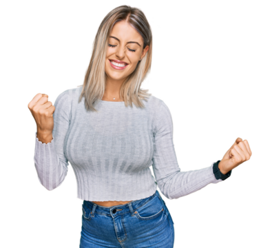 Beautiful blonde woman wearing casual clothes very happy and excited doing winner gesture with arms raised, smiling and screaming for success. celebration concept.