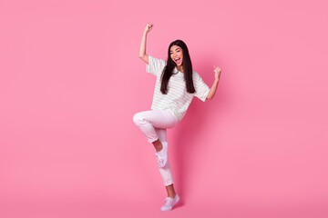 Full size portrait of indonesian positive girl satisfied raise fists success isolated on pink color background