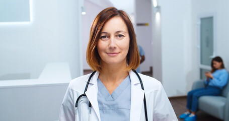 Close up portrait of happy Caucasian beautiful female physician with stethoscope in white coat...