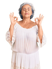 Senior woman with gray hair wearing bohemian style relaxed and smiling with eyes closed doing meditation gesture with fingers. yoga concept.