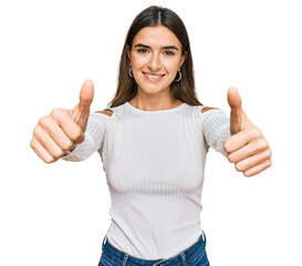 Young hispanic woman wearing casual clothes approving doing positive gesture with hand, thumbs up...