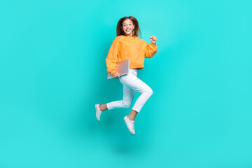 Full length photo of hurrying pretty school girl dressed orange hoodie holding modern gadget running fast isolated teal color background