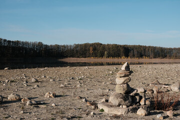 cairns stones at the dry lake coast in autumn