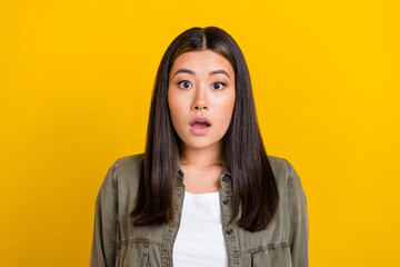 Photo of astonished speechless gorgeous woman straight hairdo dressed gray shirt impressed staring isolated on yellow color background