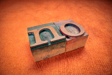 no - word in wooden letterpress printing blocks, stained by dark color inks, macro shot against...