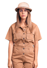 Young beautiful woman wearing explorer hat with serious expression on face. simple and natural looking at the camera.