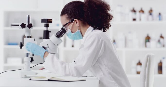 Woman, scientist and microscope in forensic experiment in lab taking notes for results, tests or discovery. Female medical expert in science research wearing protective mask and writing data findings
