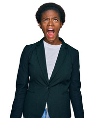 Young african american girl wearing business clothes angry and mad screaming frustrated and furious, shouting with anger. rage and aggressive concept.
