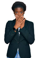 Young african american girl wearing business clothes shocked covering mouth with hands for mistake....