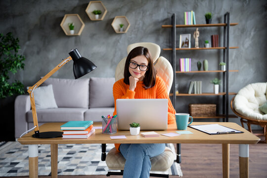 Photo of joyful pretty lady boss dressed orange jumper sitting table chatting colleagues modern macbook indoors room workstation