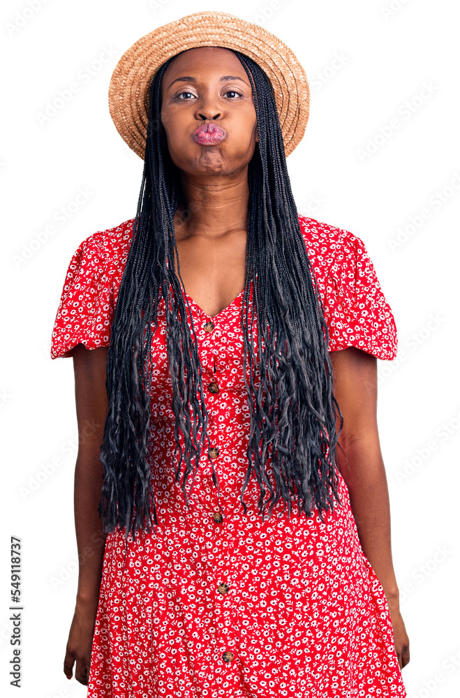 Canvas Prints Young african american woman wearing summer hat puffing cheeks with funny face. mouth inflated with air, crazy expression.