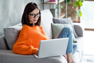 Portrait of calm concentrated responsible lady company director chief realtor choose best variant office city center sit sofa indoor