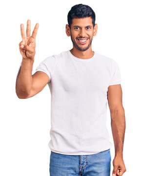 Young latin man wearing casual clothes showing and pointing up with fingers number three while smiling confident and happy.