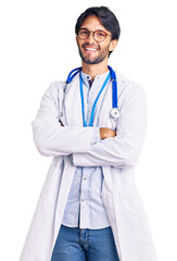 Handsome hispanic man wearing doctor uniform and stethoscope happy face smiling with crossed arms...