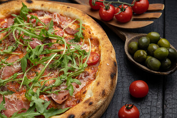 tasty pizza with cheese and vegetables on a wooden dark table
