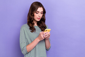 Photo of young addicted wavy hair lady hold iphone pro max chatting with her boss app for gadget empty space isolated on purple color background