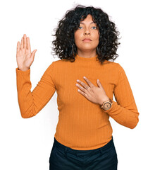 Young hispanic woman wearing casual clothes swearing with hand on chest and open palm, making a loyalty promise oath
