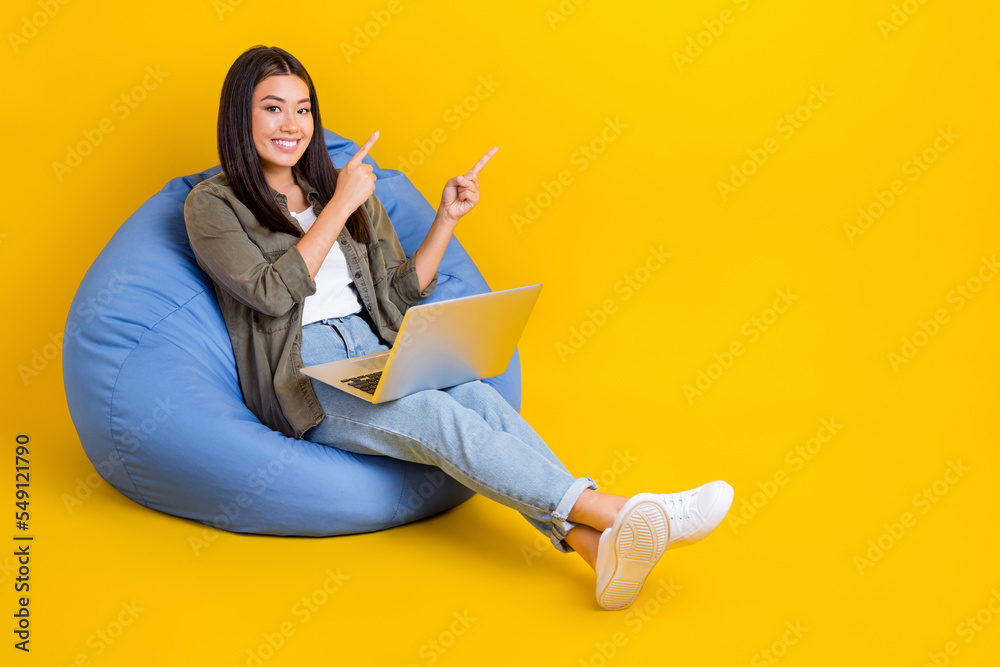 Sticker Full length photo of young chinese woman sit beanbag inside office fingers direct mockup new app for coders isolated on yellow color background