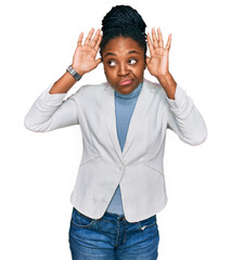 Young african american woman wearing business clothes doing bunny ears gesture with hands palms looking cynical and skeptical. easter rabbit concept.