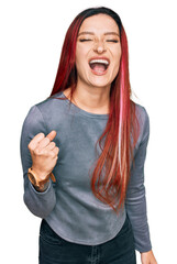 Young caucasian woman wearing casual clothes angry and mad raising fist frustrated and furious while shouting with anger. rage and aggressive concept.