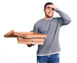 Young handsome man holding delivery italian pizza boxes stressed and frustrated with hand on head, surprised and angry face