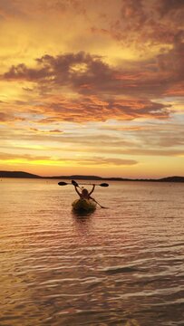Two rowers on inflatable kayak rise an oars up while they returning back from evening ride by Adriatic sea harbor in Croatia near from Sibenik city.  Vacation, sports and recreation VERTICAL 4K video