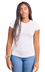 Obraz premium Young african american woman with braids wearing casual clothes smiling looking to the side and staring away thinking.