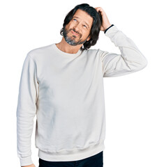Fototapeta premium Middle age caucasian man wearing casual clothes confuse and wondering about question. uncertain with doubt, thinking with hand on head. pensive concept.