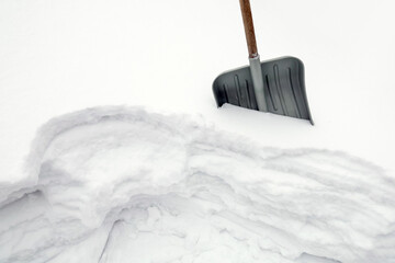 Textured surface, Snow shovel is stuck into snowdrift, snowy winter