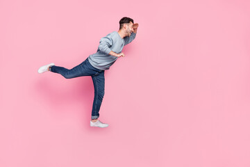 Fototapeta na wymiar Full size photo of handsome young guy carry cart searching shopping promo dressed trendy blue garment isolated on pink color background