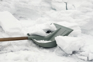 Shovel for removing snow is on surface of road, snow winter, a lot of work to clean snow