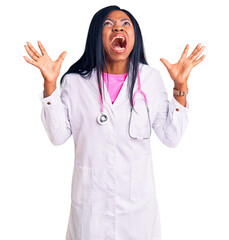 Young african american woman wearing doctor stethoscope crazy and mad shouting and yelling with aggressive expression and arms raised. frustration concept.